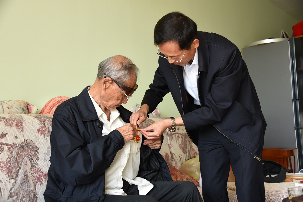 王福学书记为刘屏源同志佩戴“庆祝中华人民共和国成立70周年”纪念章