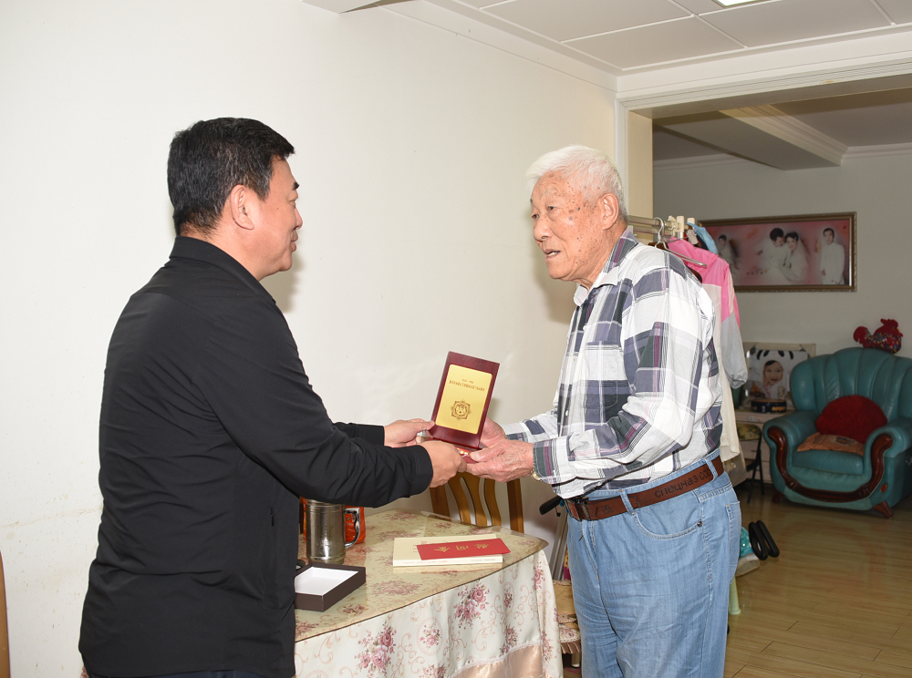 孙忠人校长为付培滨同志颁发“庆祝中华人民共和国成立70周年”纪念章